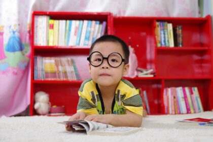 disturbi della vista nei bambini: bambino con occhiali e un fumetto