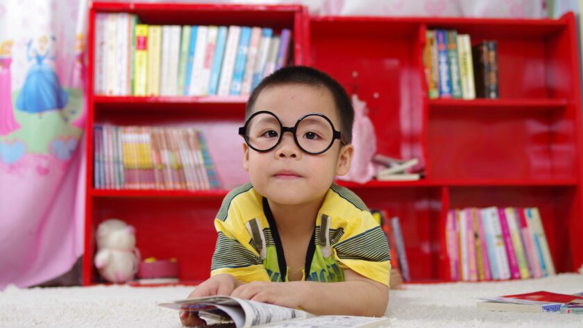 disturbi della vista nei bambini: bambino con occhiali e un fumetto